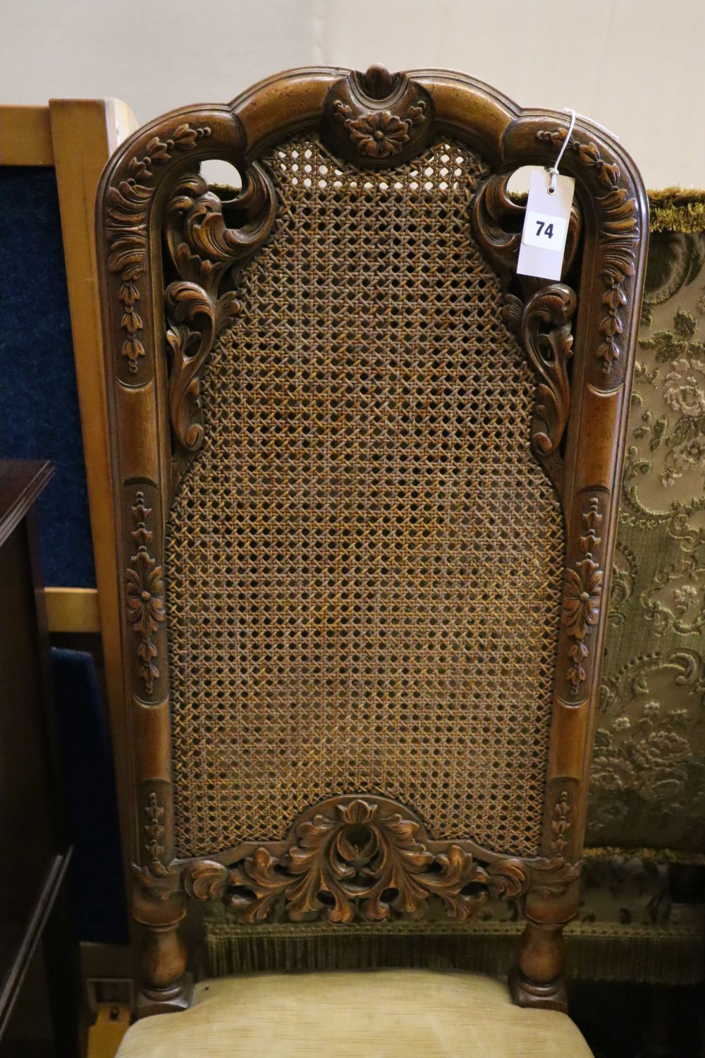 A 19th century Flemish style carved walnut armchair, upholstered in brocade and a Georgian style caned walnut dining chair